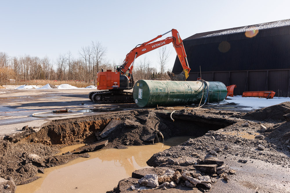 Excavator with recently removed storage tank